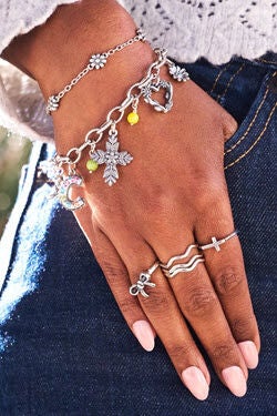 Textured Oval Charm Bracelet with several other pieces of jewelry on woman's hand