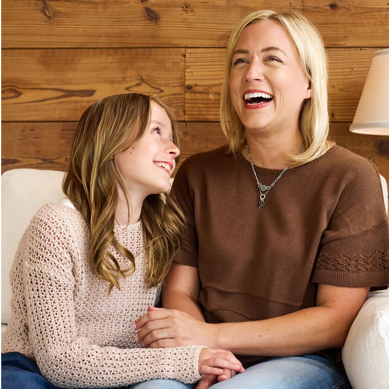 Mother and Daughter sitting on a couch having conversation