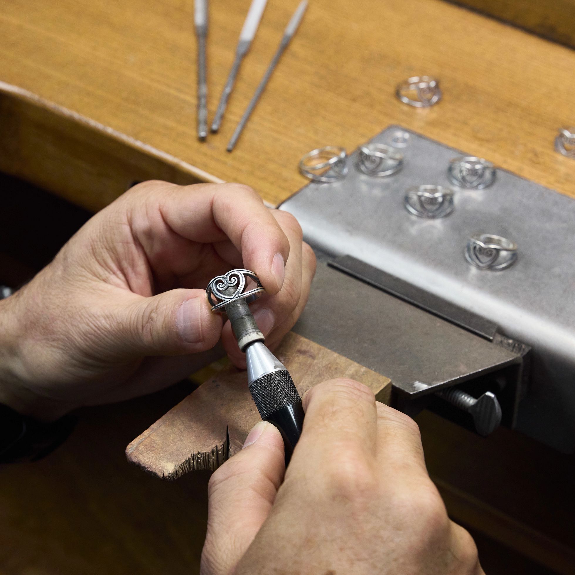 Artisan Polishing the sterling silver Traced Heart Ring at a work bench