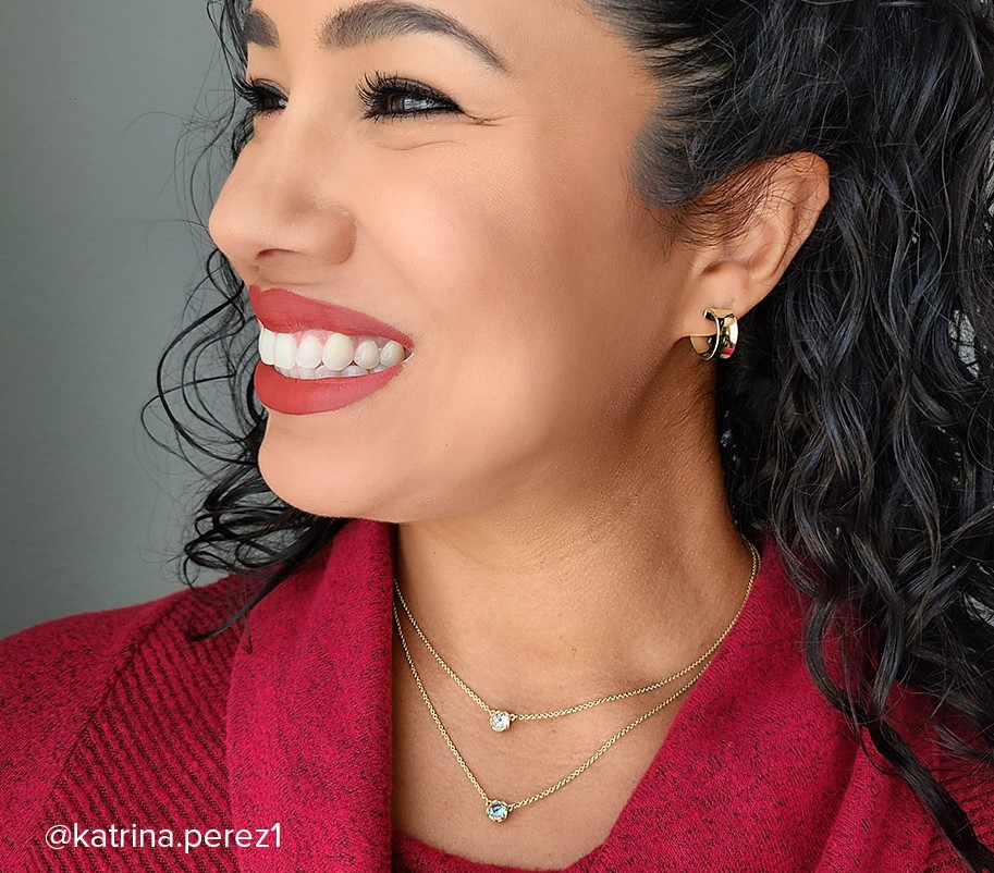 Smiling woman wearing two James Avery necklaces in 14 karat gold.