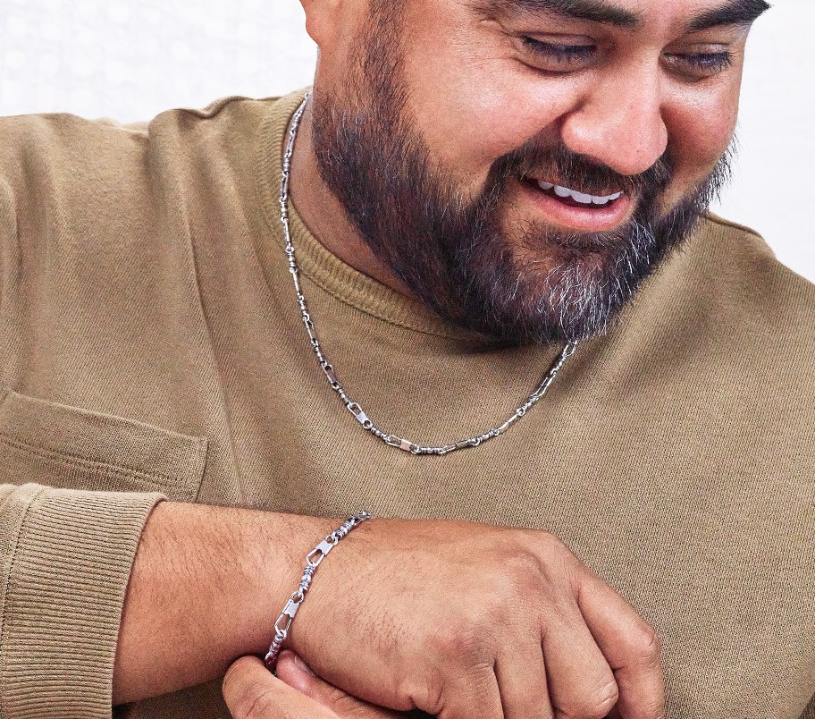 Smiling man wearing a fishers of men necklace and bracelet.
